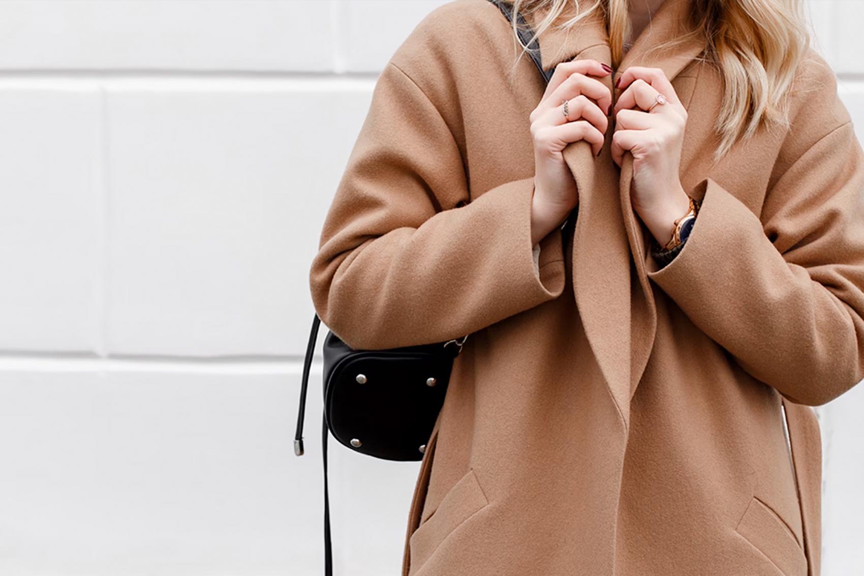 Närbild på person i brun kappa