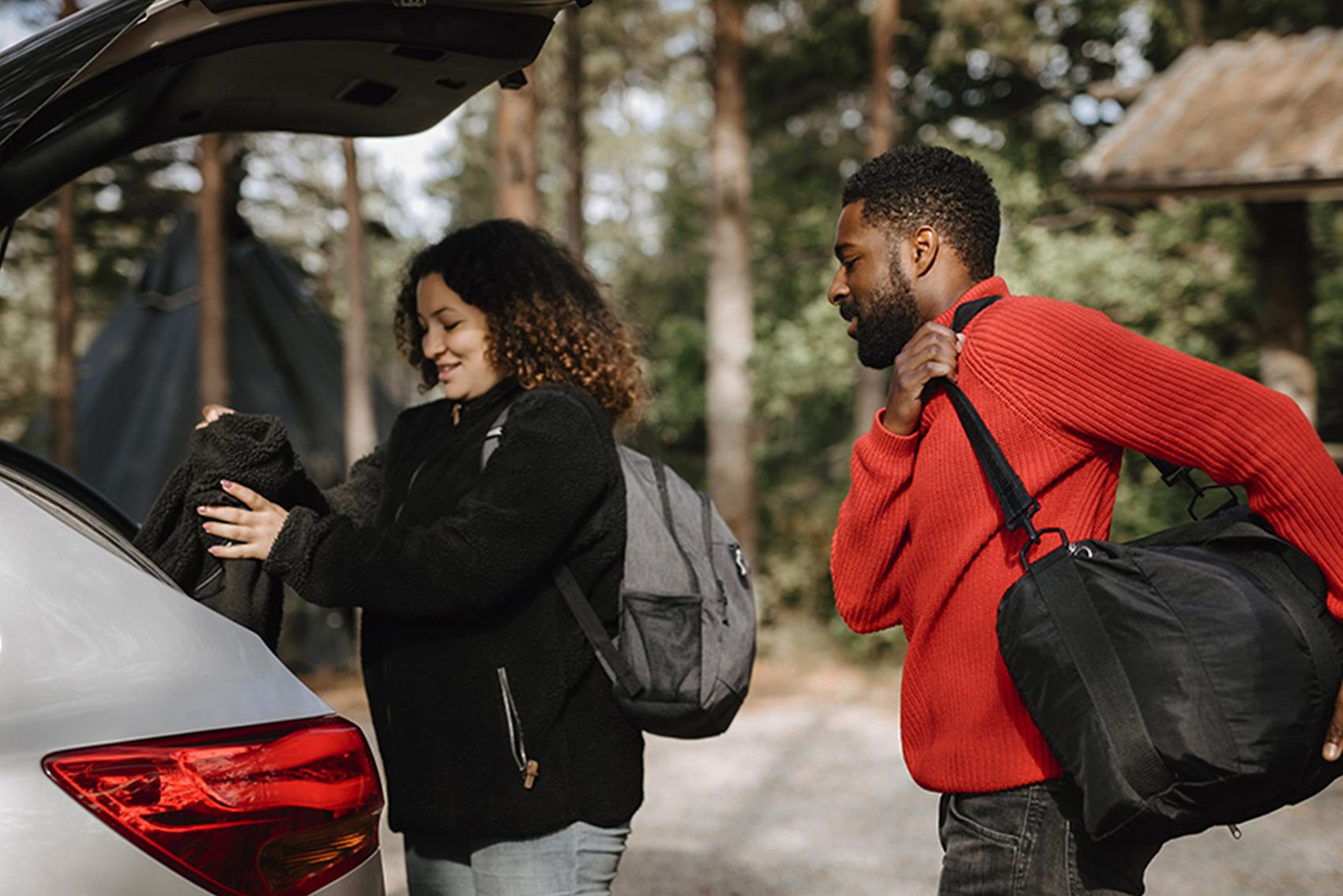 Par lägger in väskor i bagagelucka