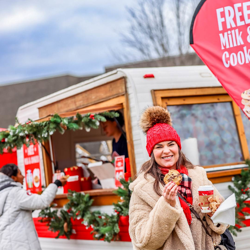 A woman enjoying a free cookie infront of the Circle K trailer at the Santa parade