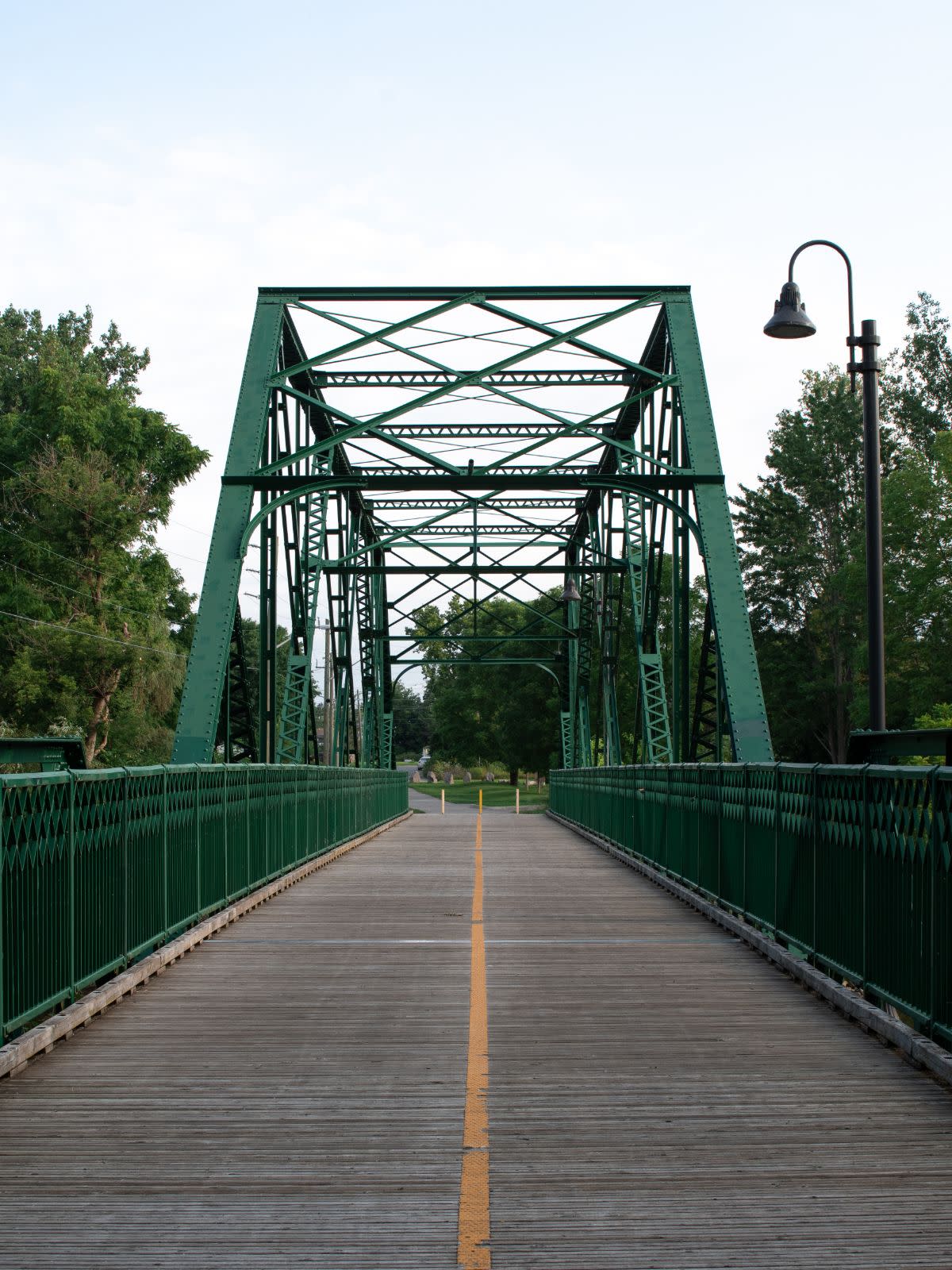 A green truss walking bridge in London, Ontario