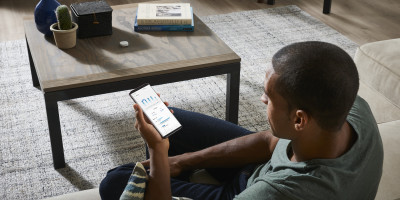 A picture of a man using the SmartThings app at home