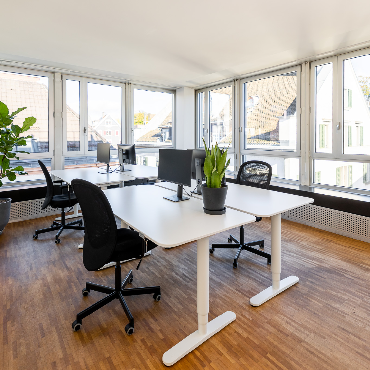 Helles Büro mit Fensterfront und Schreibtischen