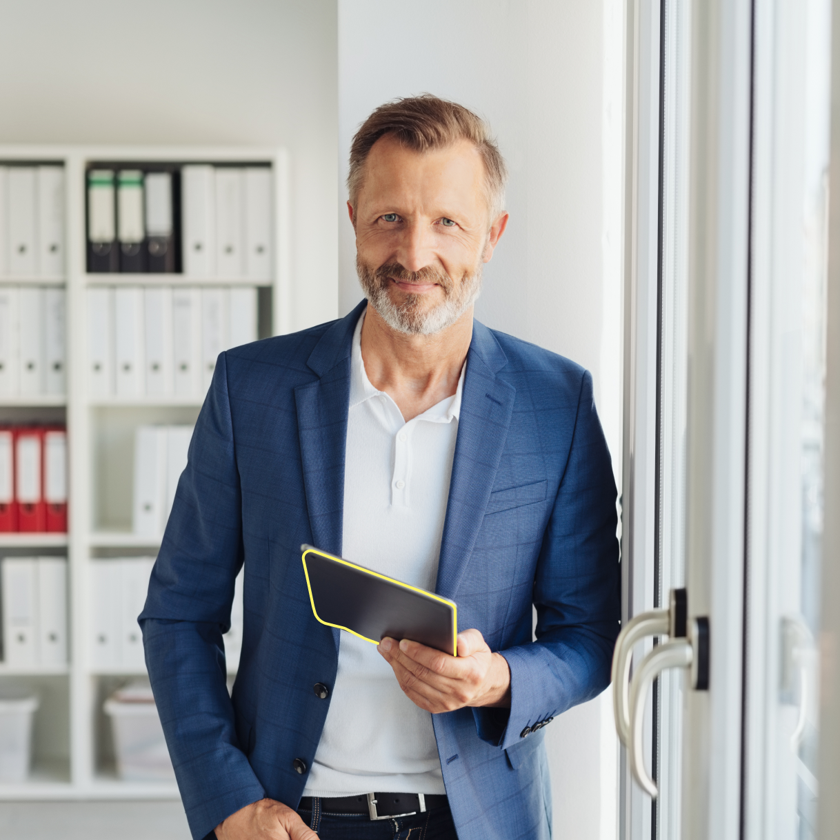 Mann im Anzug und Tablet in der Hand schaut in die Kamera