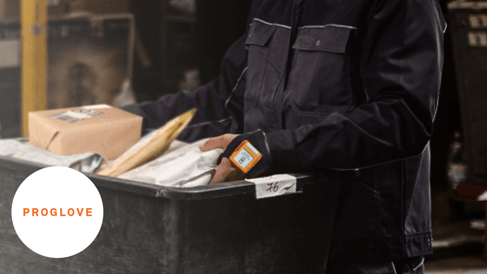 Ein Arbeiter scannt mit einem Proglove Handschuh das Etikett auf einer Box 