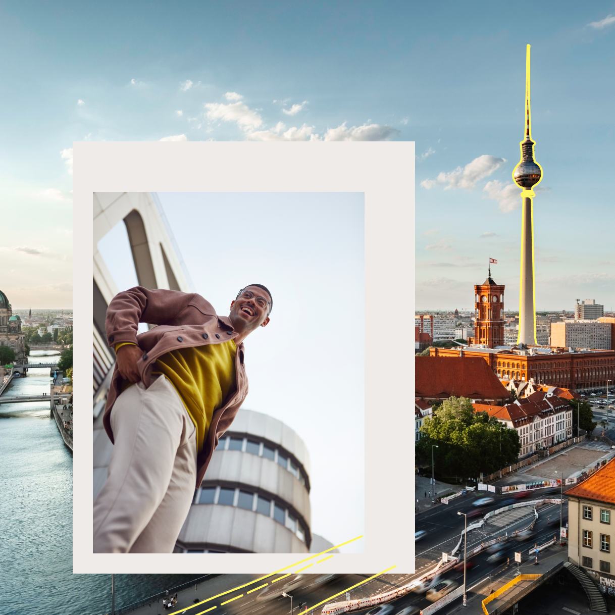 Mann im gelben Pullover steht vor Gebäude. Hinter ihm die Stadt Berlin