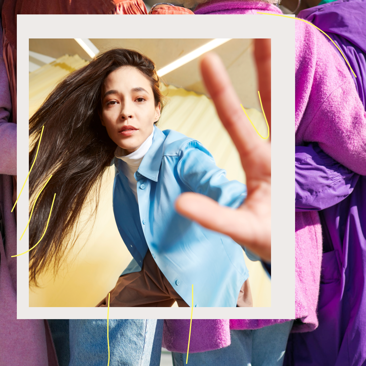 Woman in blue shirt dancing against yellow background