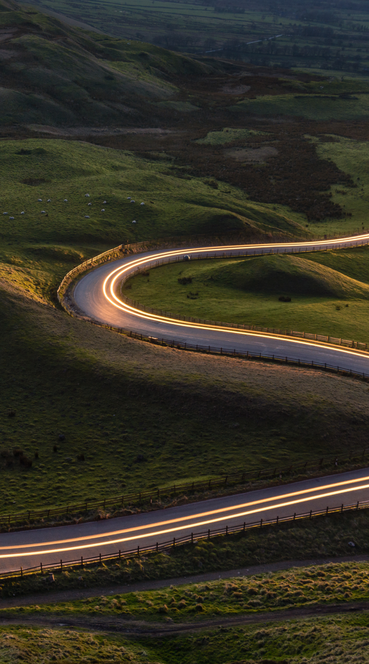 Road through green landscape with blurred lights