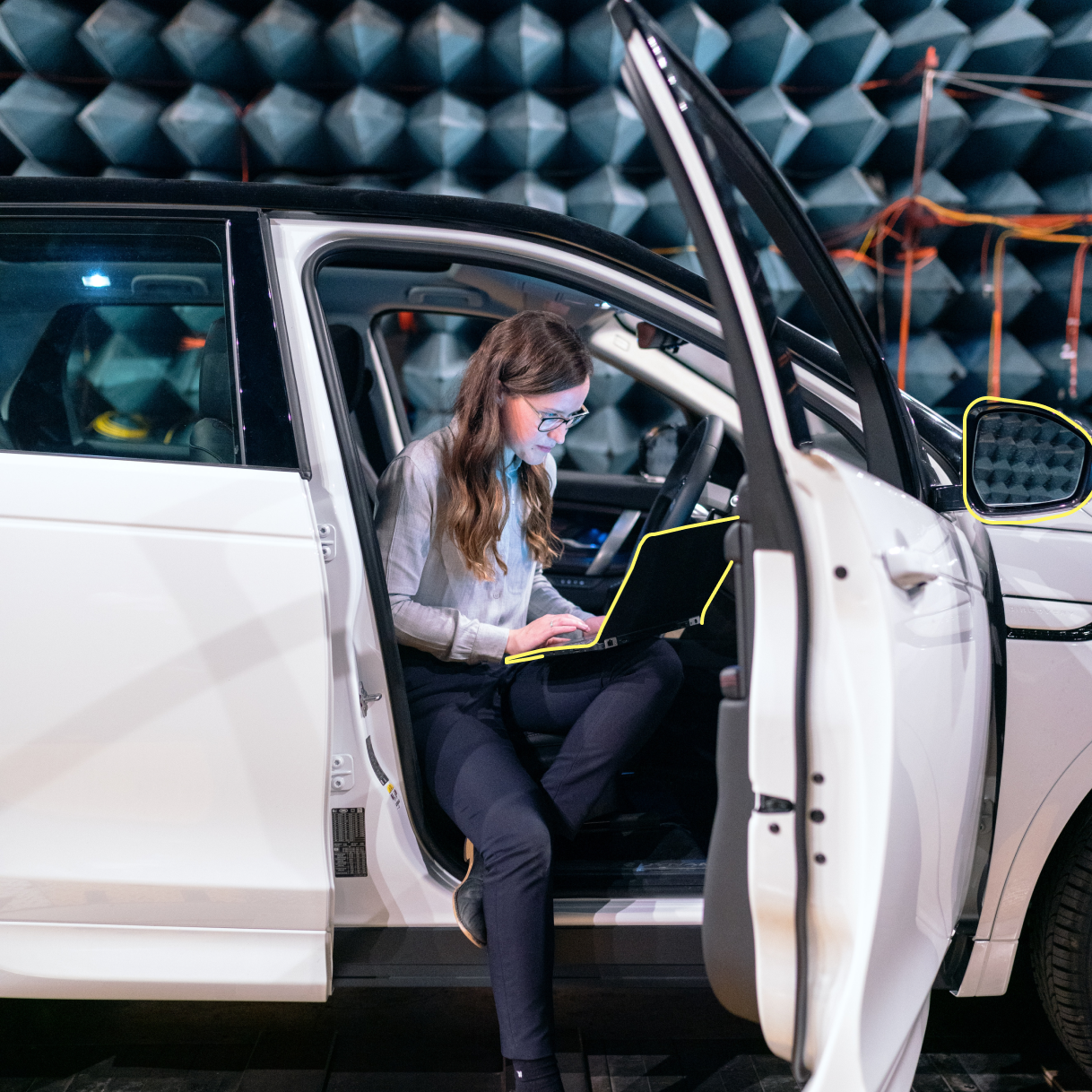 Frau testet die Akustik eines Fahrzeugs mittels digitaler Messinstrumente