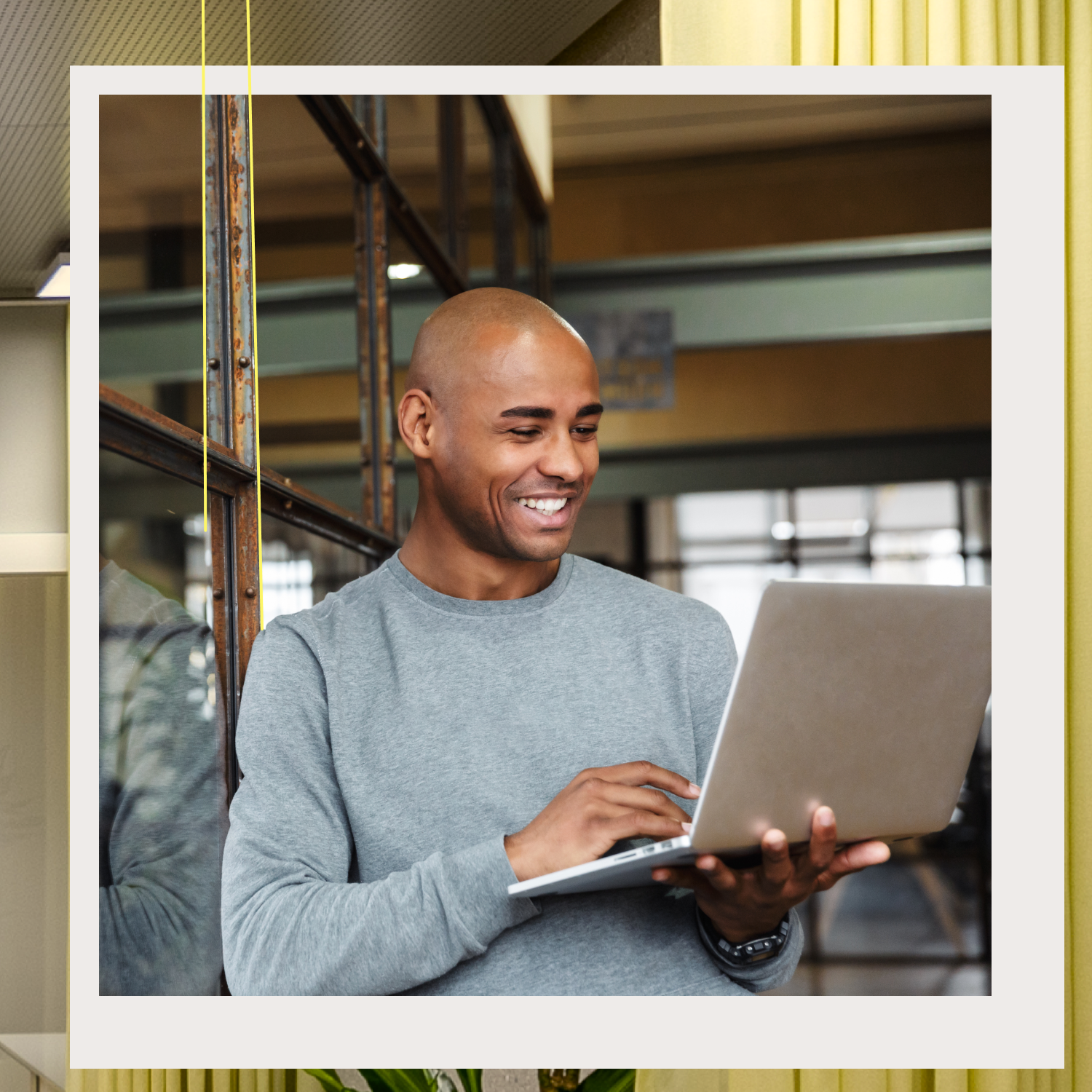 Mann blickt stehend in einen Laptop