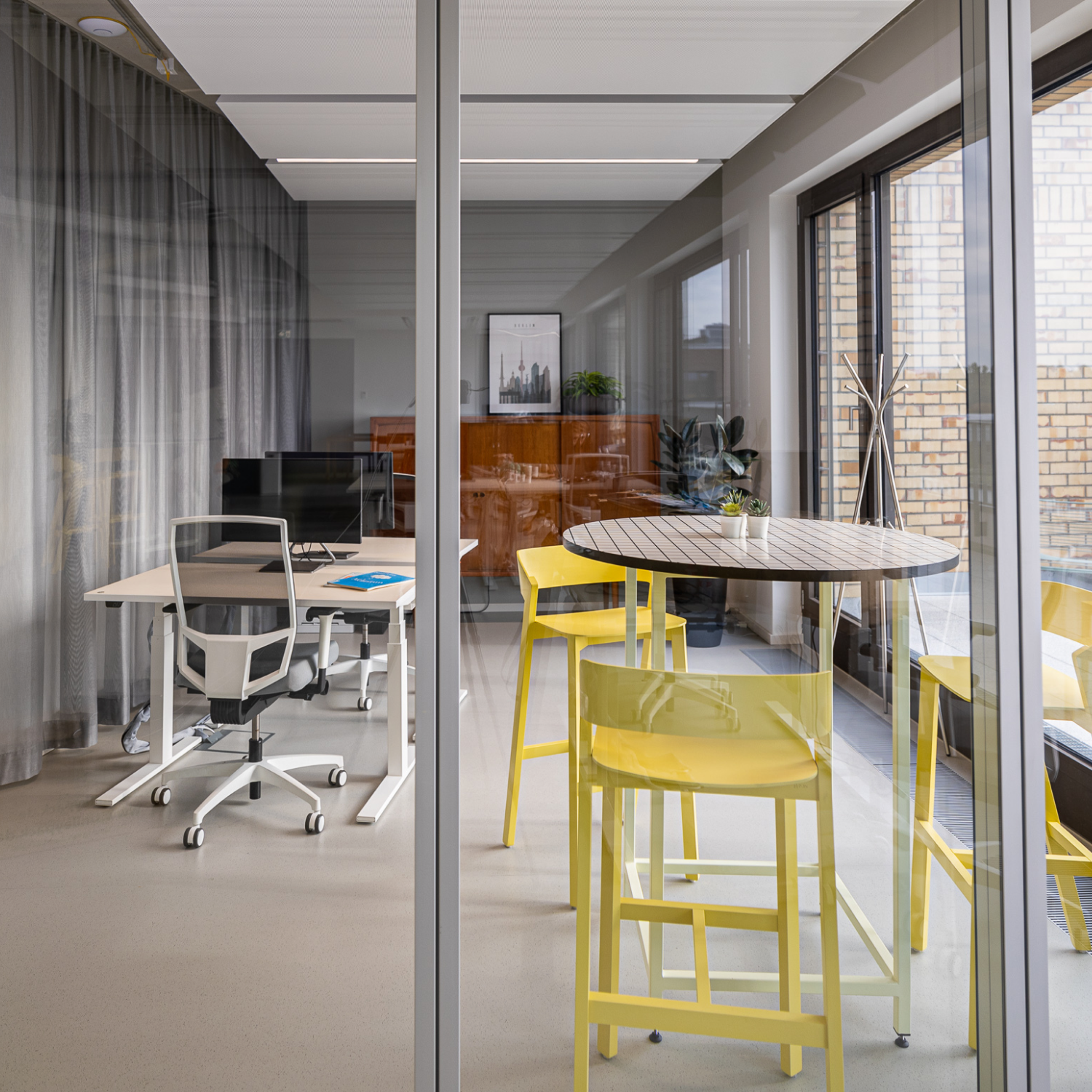 Helles Büro mit Glastür und Stehtisch im Vordergrund