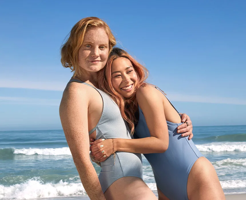 Zwei Frauen umarmen sich am Strand