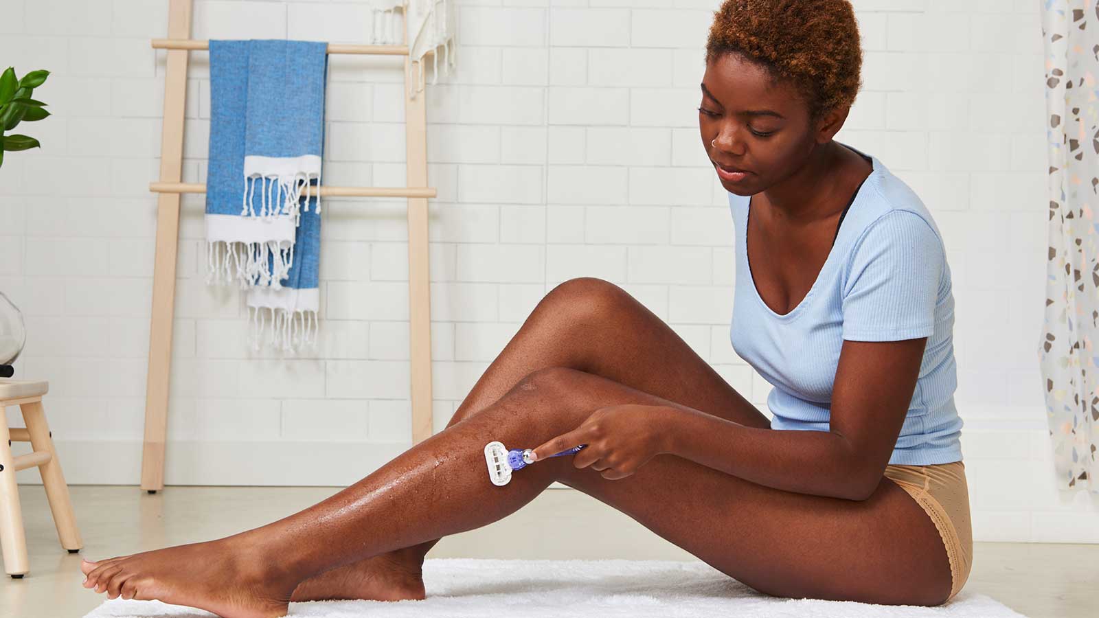 Frau rasiert sich die Beine mit dem Gillette Venus im Bad
