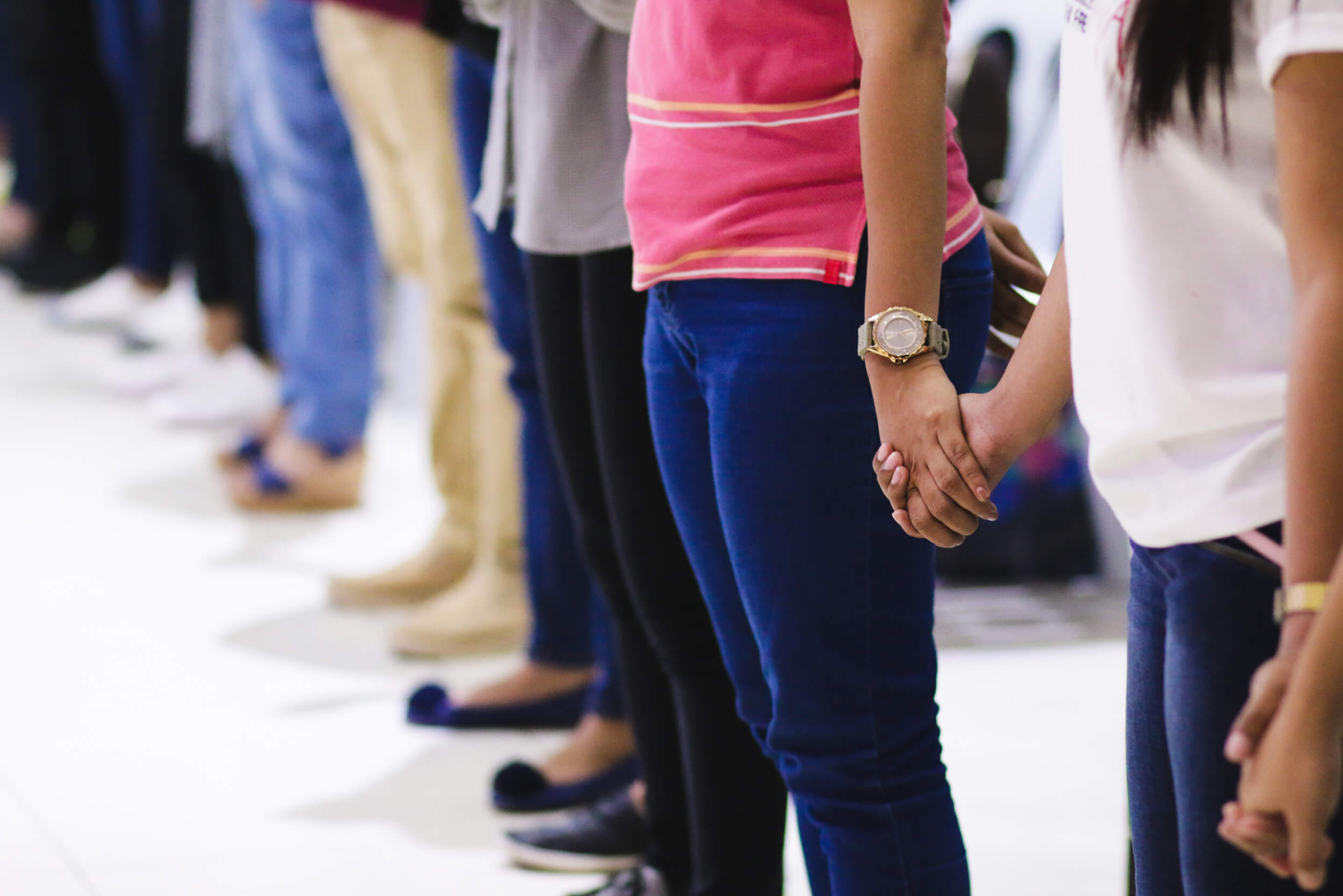 Audience members holding hands to pray
