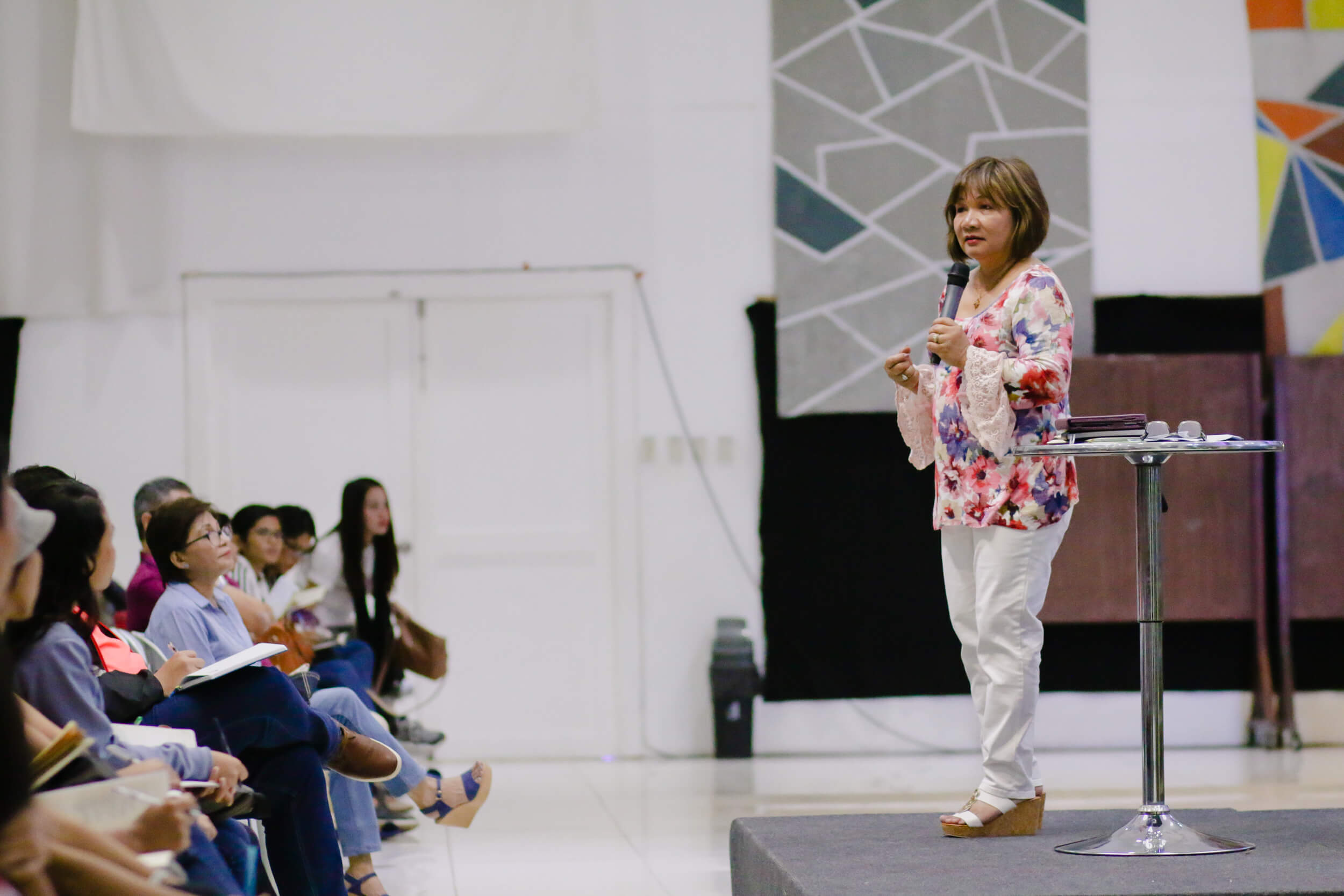Pastor Cristina Sosso speaking on an elevated platform at CCFI-Gensan in General Santos City.
