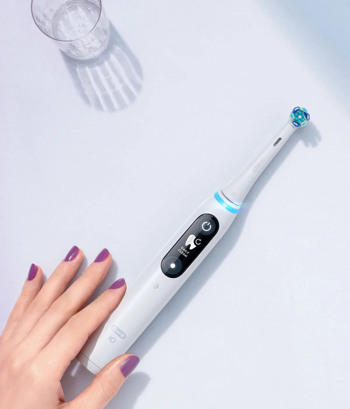 Flat lay con spazzolino elettrico Oral-B iO Series 8, occhiali da sole, borsetta e altri accessori 