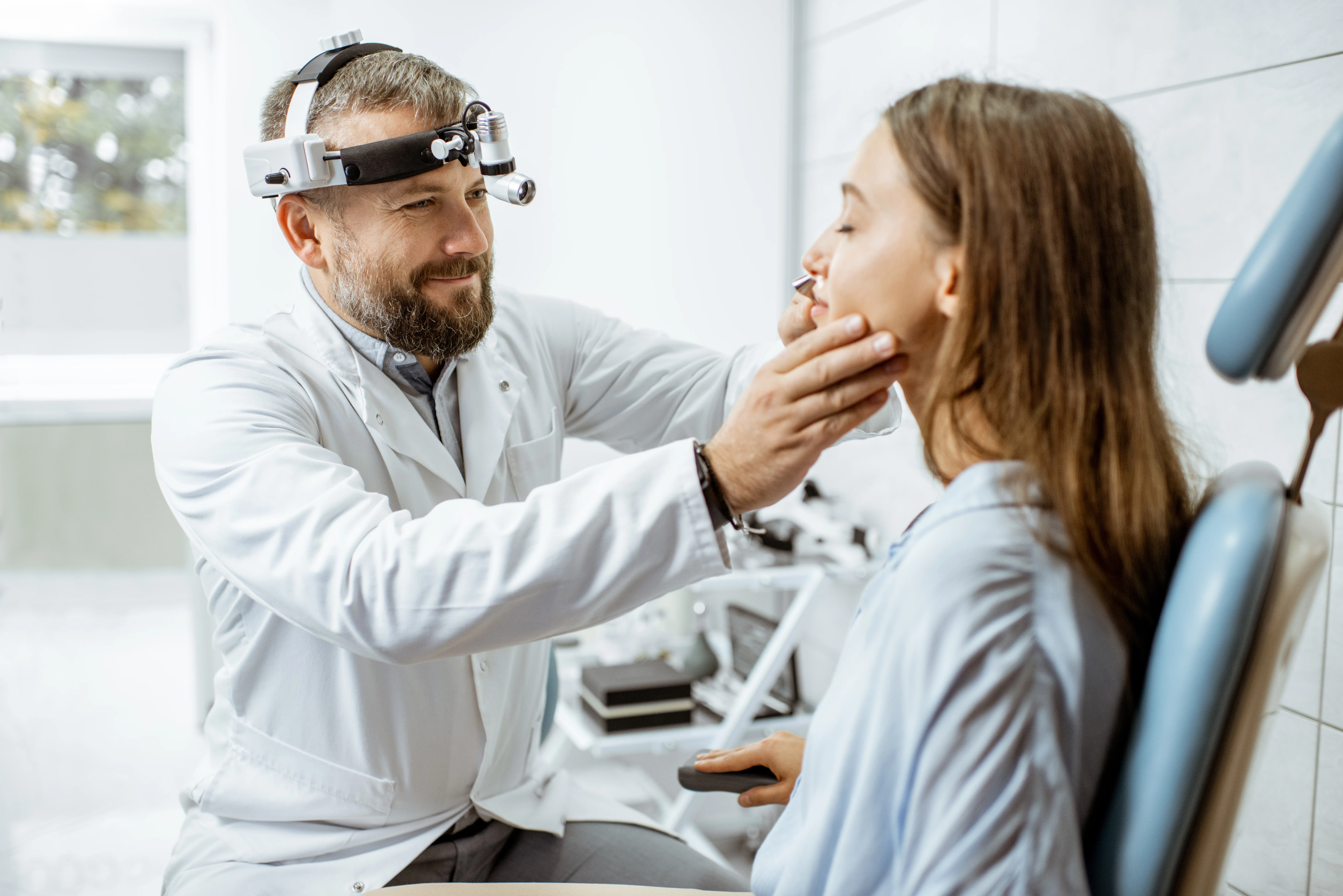 Medico che esamina la gola di una paziente