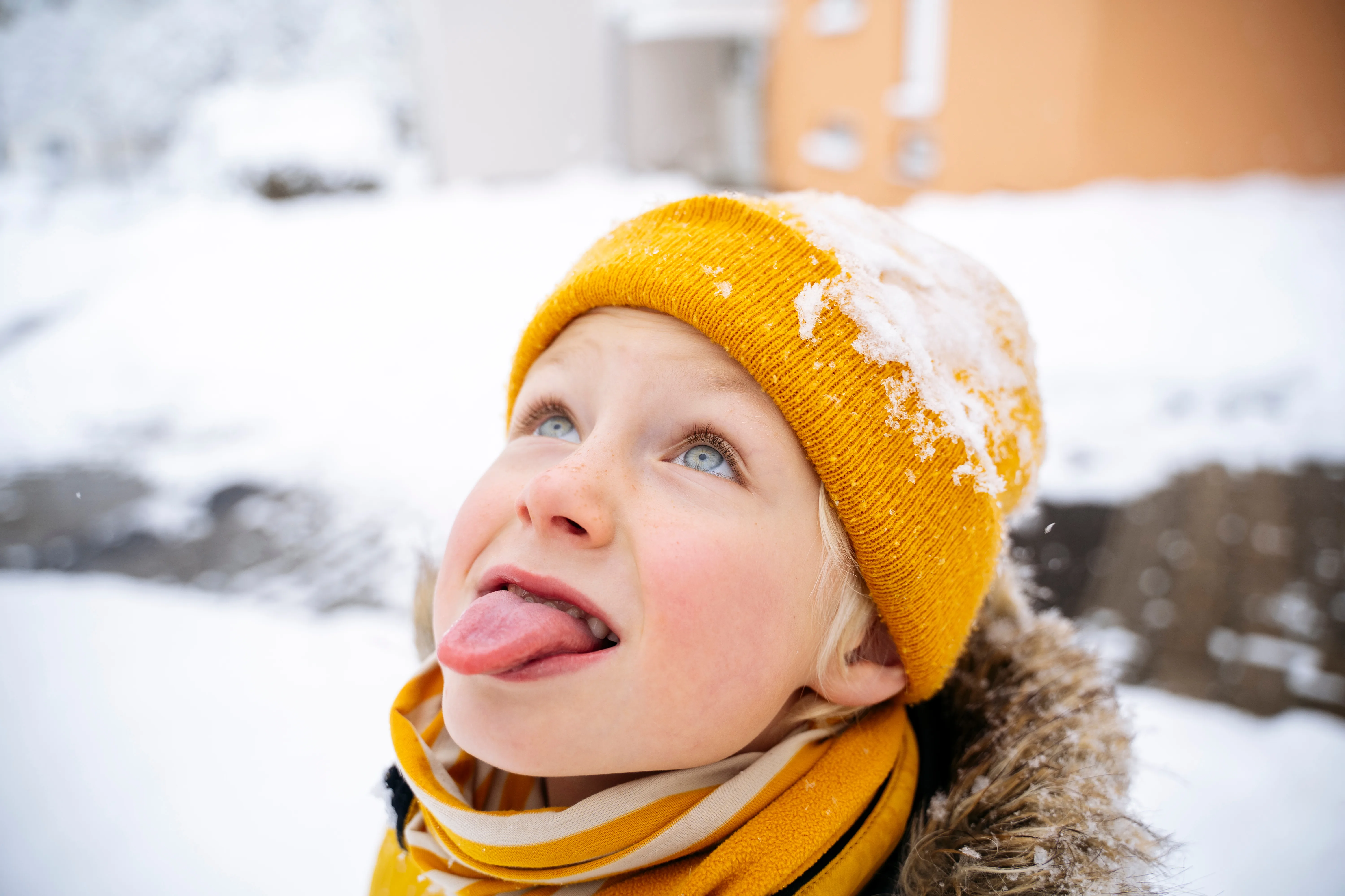 Giovane ragazzo che tira fuori la lingua per prendere la neve