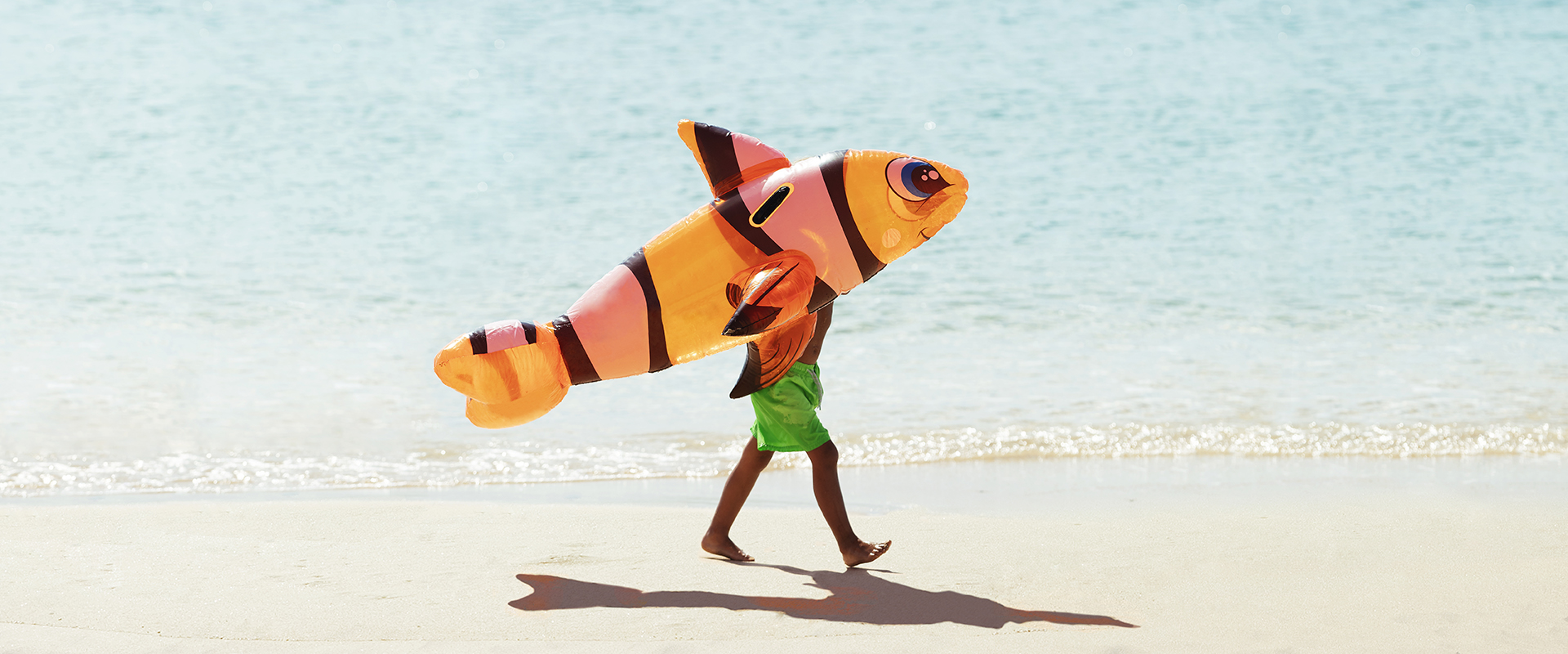 Gutt som går langs stranden.