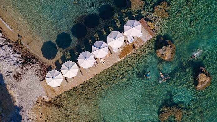 Dronebildet av strand med hvite parasoller med TUI