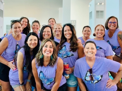 Group of 13 female friends in matching blue butterfly T-shirts.