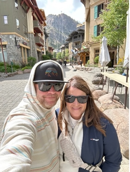 Couple posing along a cobblestone street while on vacation.