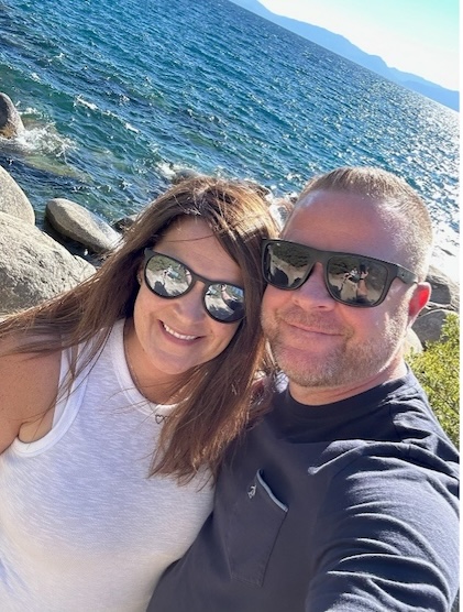 A plane in flight over a vista of land and water.  