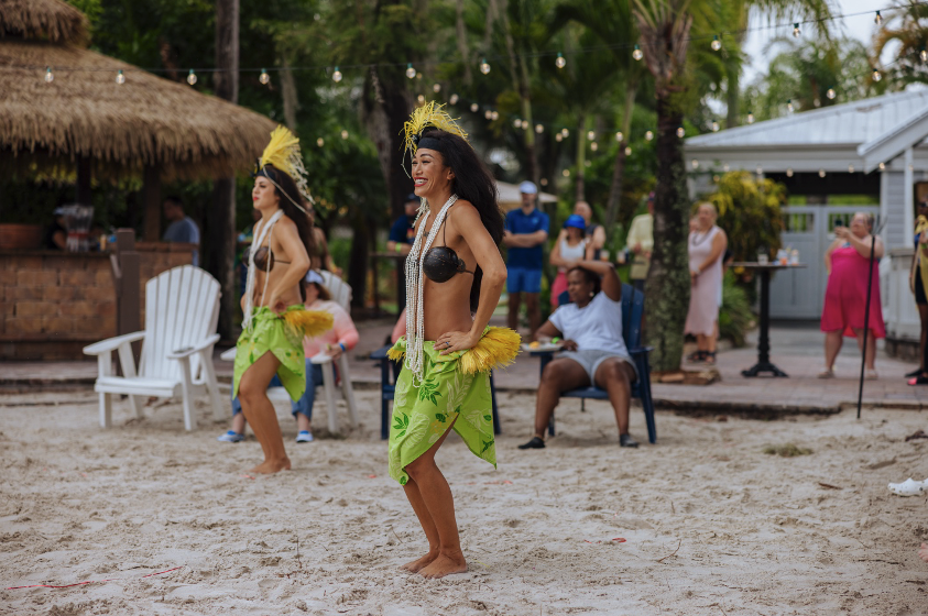 Luau performers in colorful dress perform at the Dining Beach Bash
