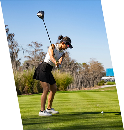 Man hitting a golf ball on the green.