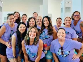 Group of 13 female friends in matching blue butterfly T-shirts.