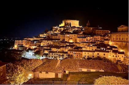 Picture of Soriano at night with a 16th century castle perched on a hill overlooking the town below.