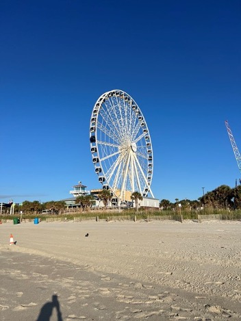 Myrtle Beach shoreline with the iconic SkyWheel Ferris wheel and other attractions in the background