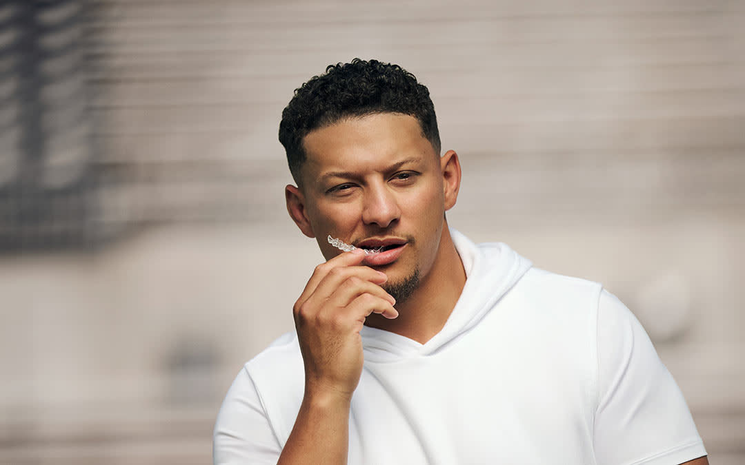 Patrick Mahomes holding Invisalign aligner