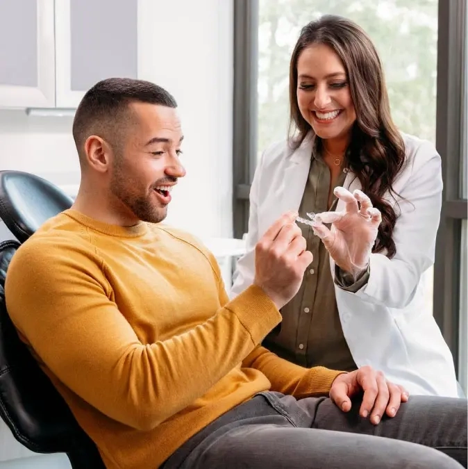 Invisalign® doctor showing her patient his new clear aligners