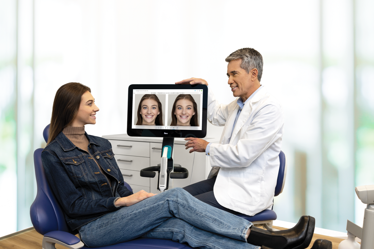 Invisalign doctor and his female patient checking her smile on iTero scanner
