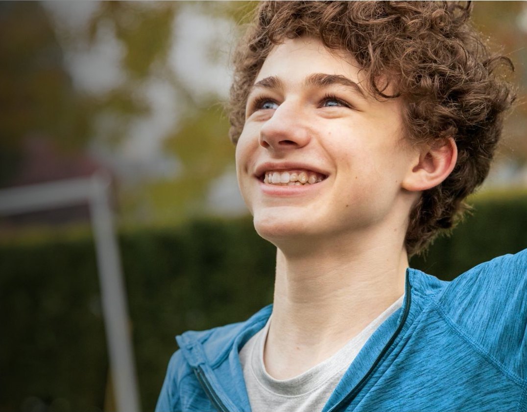 Smiling teenager wearing clear aligners