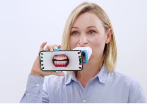 Black woman taking a picture of her tooth using Invisalign Virtual Care AI tool