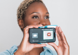Black woman taking a picture of her tooth using Invisalign Virtual Care AI tool