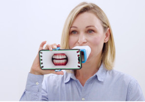 Black woman taking a picture of her tooth using Invisalign Virtual Care AI tool