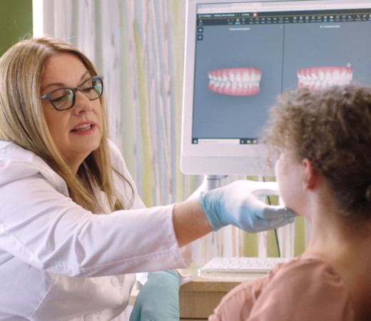 Invisalign® female doctor checking teeth to a little girl