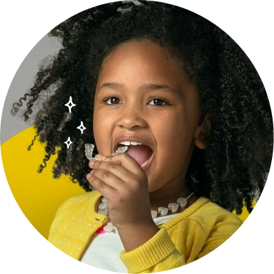 Ragazza con maglione giallo che indossa gli aligner Invisalign® First