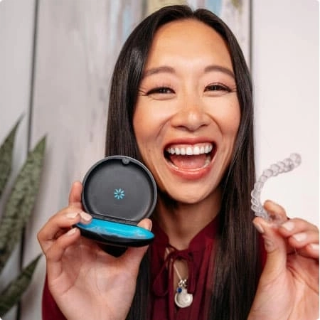 Happy woman showing her Invisalign® aligners in a case