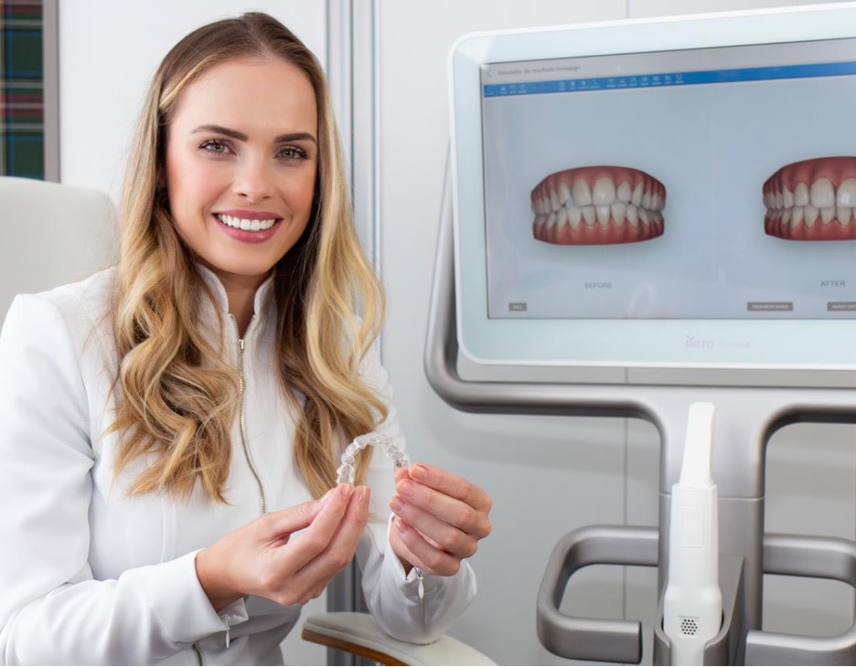 Woman holding Invisalign clear aligners