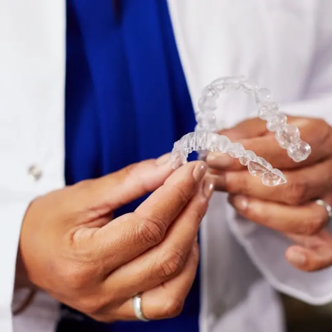 Female doctor holding Invisalign® clear aligners