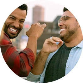 رجلان يبتسمان بثقة في الهواء الطلق بعد علاج Invisalign®
