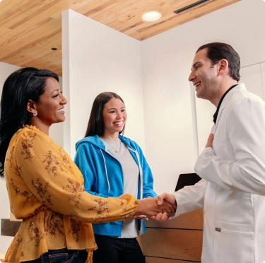 Girl teen and mom shaking hands with their Invisalign doctor