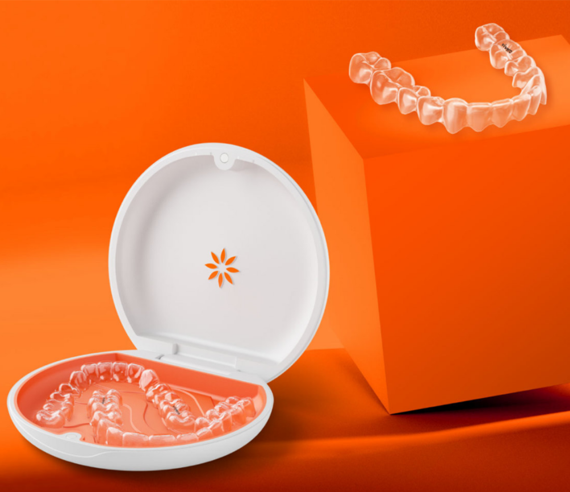 Vivera Retainers in their case on an orange background and sample retainers on an orange podium