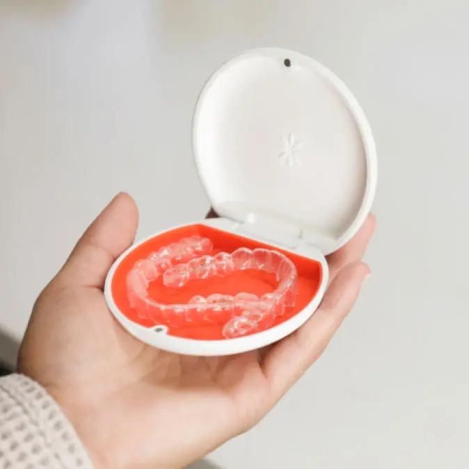 Invisalign® aligners in their orange case