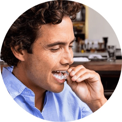 Man wearing Invisalign® clear aligners and smiling