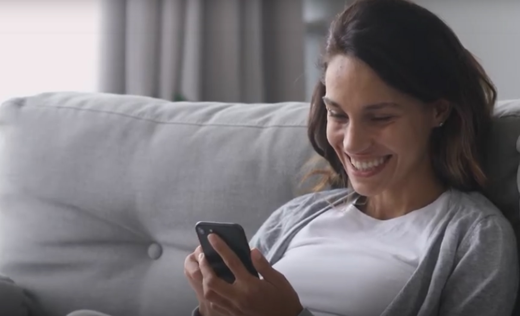 Smiling girl looking at the phone and wearing her transparent aligners