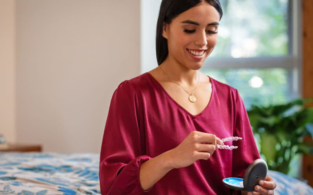Woman holding Invisalign.